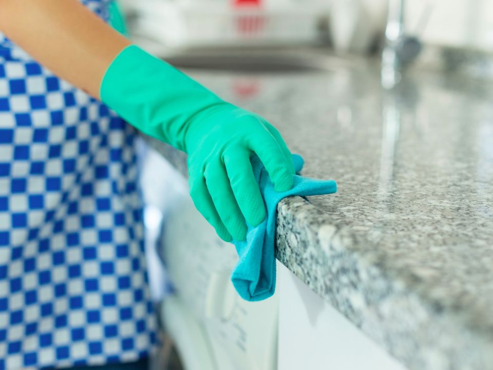 Cleaning kitchen counter in Winnetka, CA with professional cleaning services by Honest Maids.
